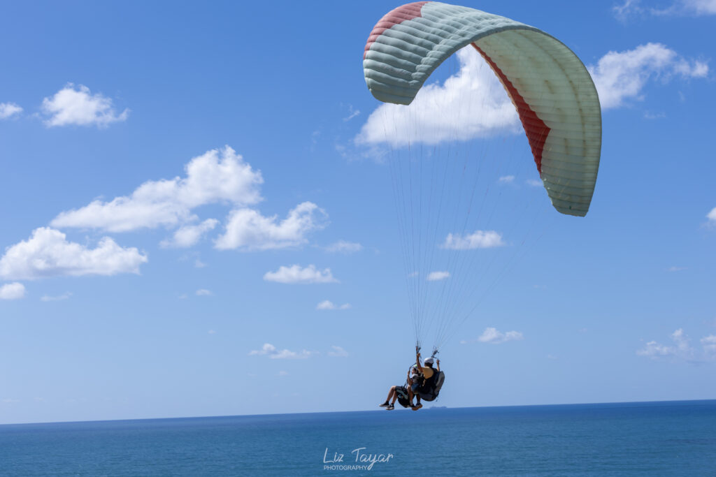 המצנח של כנפיים מצנחי רחיפה ארסוף מרחף ביום עם רוח מושלמת מעל חופי ארסוף געש הרצליה המהממים